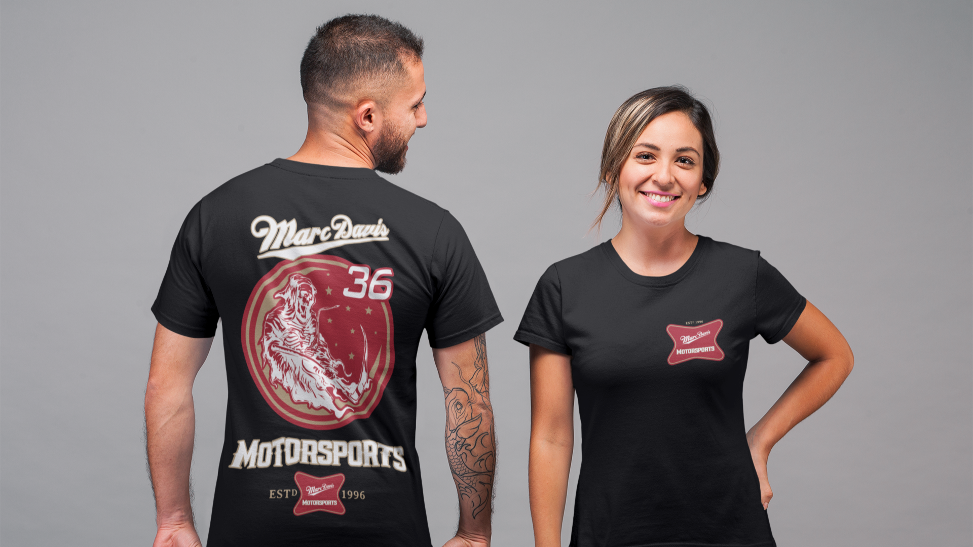 Man and woman wearing black "Ride with the Reaper" Marc Davis Motorsports T-Shirts, showing front and back designs.