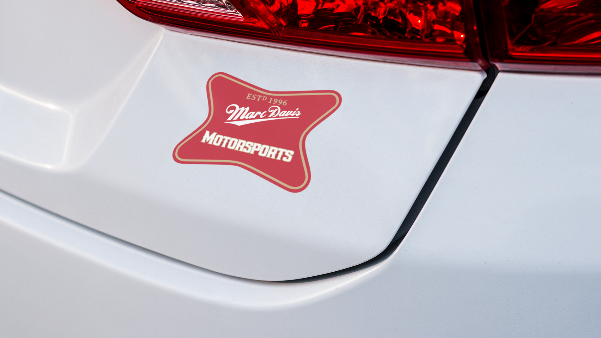 Red Marc Davis Motorsports sticker displayed on the rear of a car.
